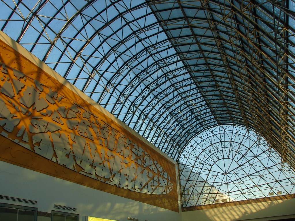 Glazen boogdak met metalen constructie en decoratief paneel